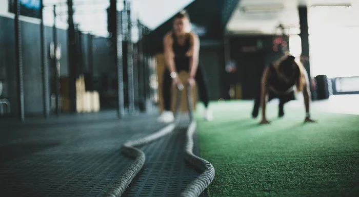 Person using heavy battle ropes during a varied gym workout